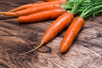 Close up of fresh carrot on rustic wooden background, top view