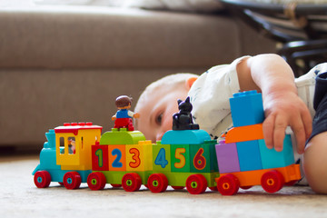 Fototapeta premium child on the floor playing with a color class train