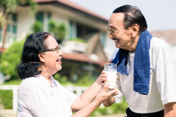 Senior couple holding glass of milk