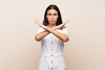 Young woman over isolated background making NO gesture