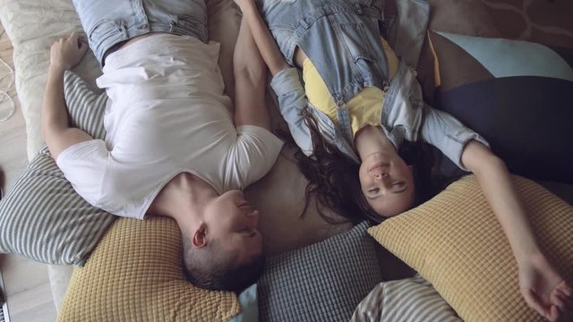 Joyful young couple of newlyweds lie on the bed and enjoy