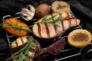 Grilled fish with rosemary and vegetables on grid