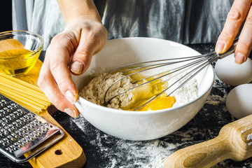 cooking pasta by chef in kitchen on dark background