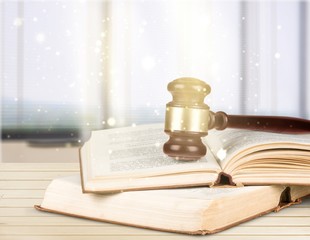 Wooden gavel  and books on background, conceptual of a judge, courtroom and judgements