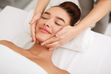 Face massage. Woman getting spa treatment in salon