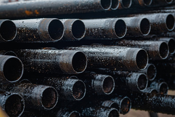 Oil Drill pipe. Rusty drill pipes were drilled in the well section. Downhole drilling rig. Laying the pipe on the deck. View of the shell of drill pipes laid in courtyard of the oil and gas warehouse