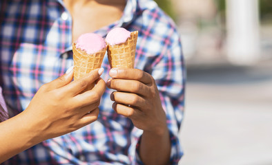 Young couple eating ice cream cones together