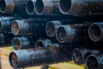Oil Drill pipe. Rusty drill pipes were drilled in the well section. Downhole drilling rig. Laying the pipe on the deck. View of the shell of drill pipes laid in courtyard of the oil and gas warehouse