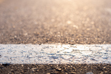 White painted line in a parking lot on a grey rough surface with copy space – Vertical mark on the street