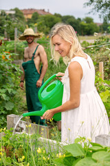 couple in the garden watering the flowers