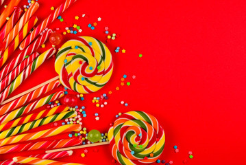Fototapeta na wymiar Colorful candies on a red background. Lollipop. Top view. Copy space.