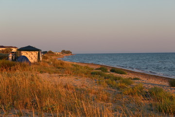 house on coast of sea at sunset