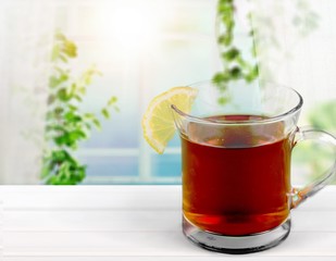 Tea with sliced lemon on background