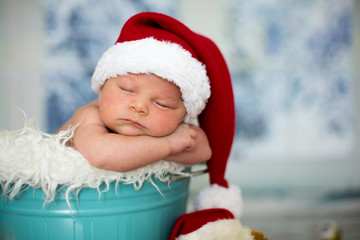 Portrait of a newborn baby boy,l wearing christmas hat, sleeping