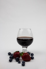 Glass of wine. Festive mood. Alcohol for a group of friends. Tasty drink. Noble drink. Isolate Berries and wine. copyspace