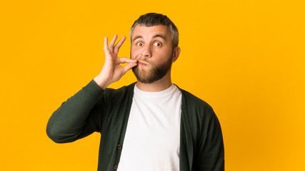 Handsome caucasian man zipping his mouth with gesture © Prostock-studio