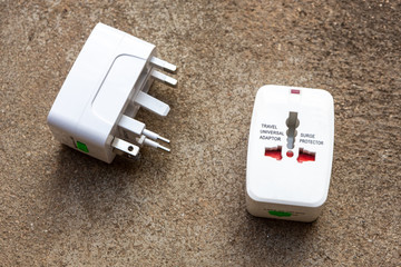 Close up of universal electric socket plug adapters used for travel. Used to connect to different electrical outlets worldwide. Electric adapter isolated on dark background.