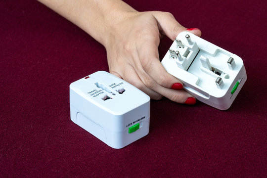 Close up of universal electric socket plug adapters used for travel. Used to connect to different electrical outlets worldwide. Electric adapter isolated on dark background.