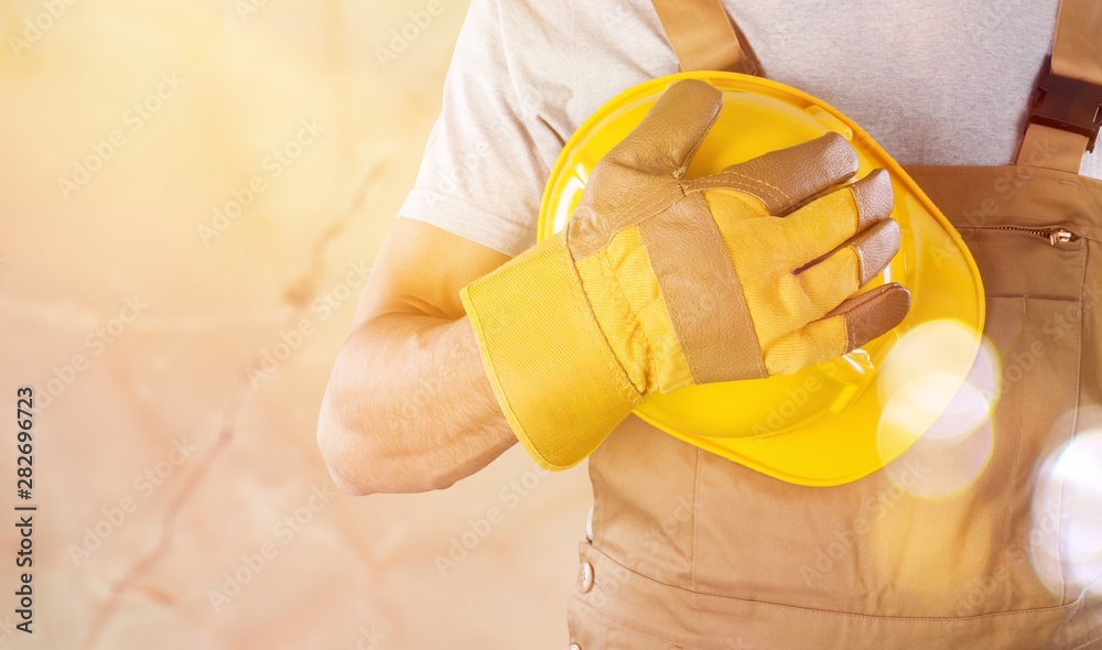 Wall mural Worker man with helmet on background