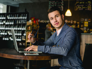 Emotional businessman with laptop in cafe