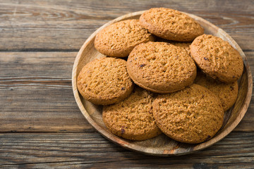 Oatmeal cookies in a wooden plate on a wooden table. rustic style
