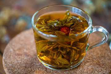 Tasty herbal tea in glass teapot on old wooden table