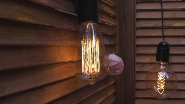 Decorative antique edison style filament light bulbs hanging on wooden wall. Incandescent lamp bulb