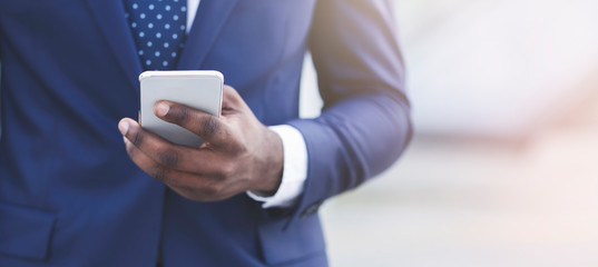Afro Businessman Sending Messages Via Cellphone Walking Outdoor, Closeup, Crop