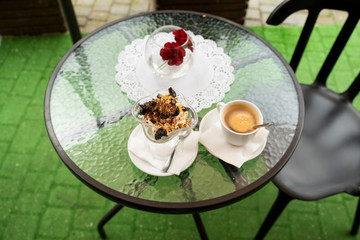 glass table with a sweet dessert and with cream and coffee
