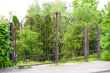 Metal forged gates with a gate for cars to enter the courtyard and security