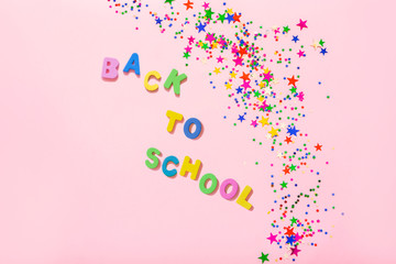 Group of colorful glitter stars decoration, merry christmas, happy new year isolated on pink background object design on top view.  Stars shaped confetti with colorful letters back to school.