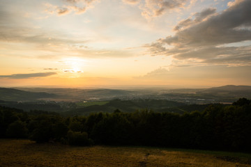 Landscape view on meadow with blue sky with many clouds and forest close to city Valasske Mezirici captured during summer late time.