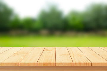 Wood floor with blurred trees of nature park background and summer season, product display montage