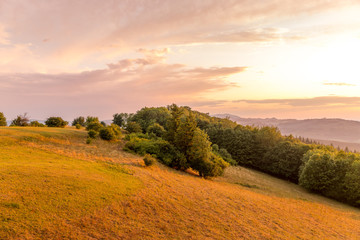 Fototapeta premium Meadow landscape countryside view with blue sky with many clouds sun light and forest close to city Valasske Mezirici captured during summer late time from hill.