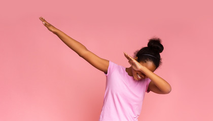 Teen girl throwing dab move standing against pink background