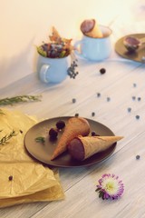  Homemade chocolate ice cream in waffle cones, berries on a wooden table, healthy dessert
