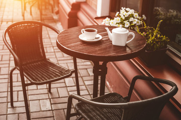 Street view of a summer terrace cafe with table and chairs.