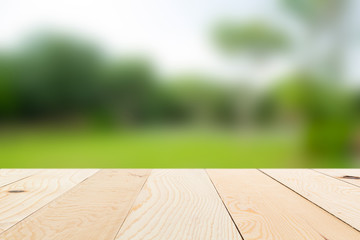 Wood floor with blurred trees of nature park background and summer season, product display montage