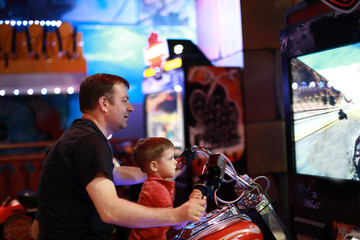 Father and son playing motorbike simulator