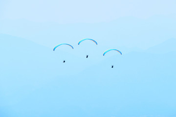 Paraglider flying over the Garda Lake (Lago di Garda or Lago Benaco). Paragliding on Monte Baldo. Panorama of the gorgeous Garda lake surrounded by mountains, Malcesine, Italy