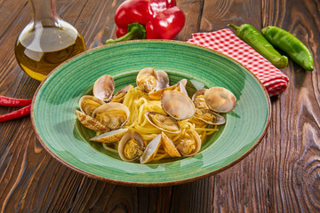 Italian seafood pasta with clams on wooden background