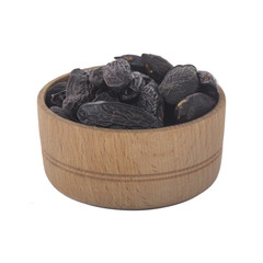 heap of tonka beans in wooden cup isolated on white background