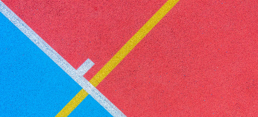 Colorful sports court background. Top view to red and blue field rubber ground with white and...