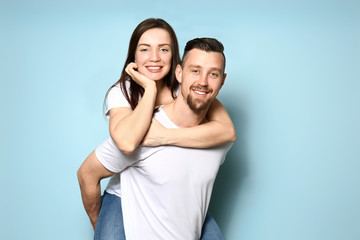 Happy young couple on color background