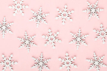 Christmas background. White snow decorations on a pink background.