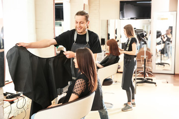 Male hairdresser working with client in salon
