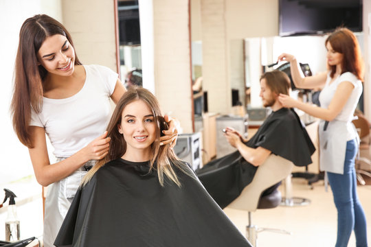 Female hairdresser working with client in salon