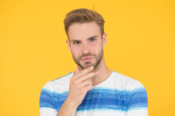 Bearded moderately. Bearded man on yellow background. Unshaven guy touching his bearded chin....