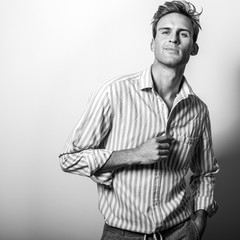 Elegant young handsome man in classic shirt. Black-white portrait.