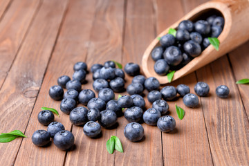 Scoop with ripe blueberry on wooden background